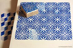 a blue and white patterned paper with a rubber stamp on it