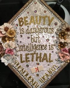 a graduation cap decorated with flowers and writing on the front that says, beauty is dangerous but intelligente is letha