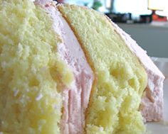 a piece of cake with pink frosting on it sitting on a plate next to a fork