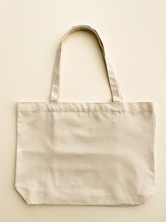 "Our Minimalist Wide Tote makes for the summer beach bag. To increase the functionality, we added interior pockets so you can keep your small items right where you want them.  -Can hold up to 34 lbs -Hand painted in the US -Interior pockets, magnet closure -Size: 18\" width by 13\" height -Strap length: 23" Minimalist Beige Bag For On-the-go, Simple Cream Bag For Everyday Use, Eco-friendly On-the-go Bags With Pockets, Minimalist Cream Travel Bag, Minimalist Beige Bags For On-the-go, Reusable Canvas Shoulder Bag For Everyday Use, Everyday Reusable Canvas Shoulder Bag, Reusable Rectangular Bag For On-the-go, Minimalist Cream Bag For Everyday Use