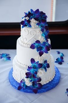 a wedding cake with blue and white flowers on it