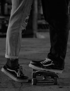 two people standing next to each other on skateboards