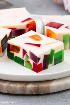 four pieces of multicolored jello on a white plate