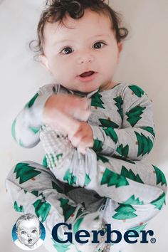 a baby wearing pajamas and pointing at the camera with his hand on top of it