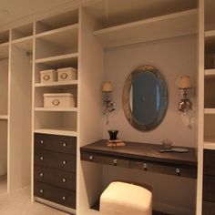 an empty dressing room with white walls and drawers