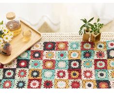 a crocheted tablecloth with flowers on it and a bottle of oil next to it