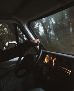 a man driving a truck in the dark with his hands on the steering wheel and dashboard