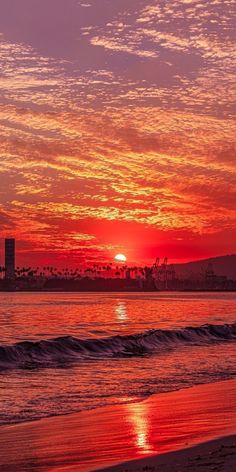 the sun is setting over the water at the beach