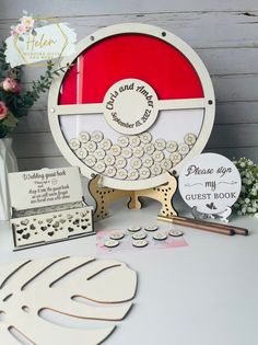 a table topped with paper cut outs and other crafting supplies next to a vase filled with flowers