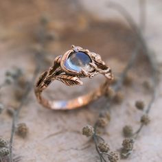 a close up of a ring with a stone in it on top of some flowers