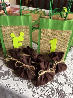 some bags are sitting on a table with brown burlocks and green paper tags