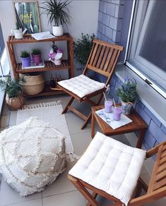 an image of a balcony setting with furniture and plants on the windowsill, while someone is taking a photo