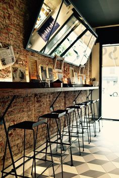 there are many bars with stools at the bar in front of the television screen