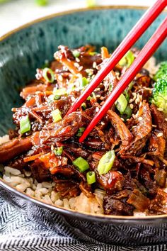 beef and broccoli stir fry in a bowl with chopsticks on top