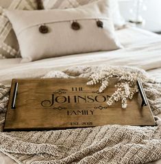 a wooden sign sitting on top of a bed next to pillows and throw pillows in front of it