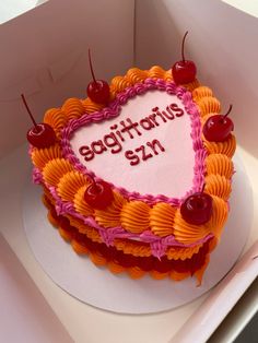 a heart shaped birthday cake in a box with congratulations written on the top and cherries