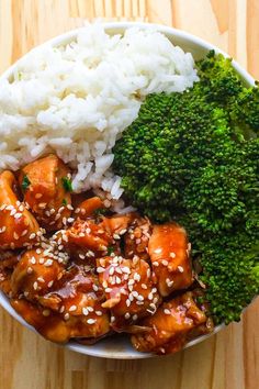 a bowl filled with rice, broccoli and chicken next to white rice on a wooden table