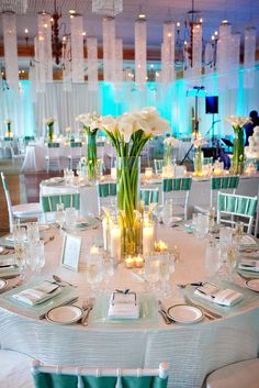 the table is set with white flowers and candles for an elegant dinner or banquet event