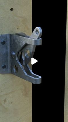 a close up of a metal hook on a wooden door with black and white stripes