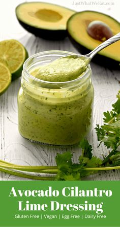 avocado cilantro lime dressing in a glass jar with a spoon next to it