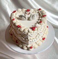 a heart shaped cake with two doves in the shape of a heart on top