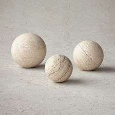 three wooden balls sitting on top of a cement floor