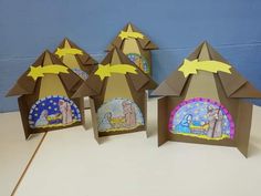 three paper houses with nativity scenes on them