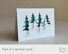 a white card with green trees on it and the words pack of 4 identical cards