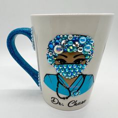 a blue and white coffee cup with a woman's face on the side, surrounded by beads