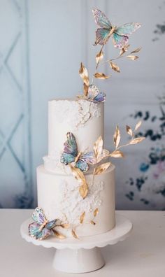 a white cake with gold butterflies on top