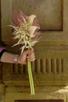 a woman holding a bouquet of flowers in her hand