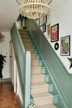 the stairs in this house are painted blue and have pictures hanging on the wall above them