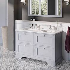 a bathroom with two sinks and mirrors on the wall