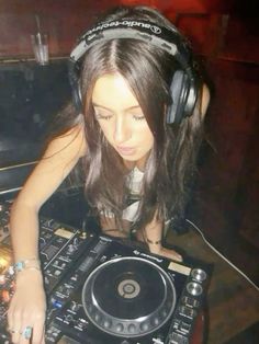 a woman wearing headphones is playing music on a turntable