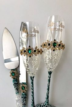 two wine glasses sitting on top of a table next to a silver knife and fork