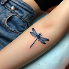 a woman's arm with a dragon tattoo on the left side of her arm