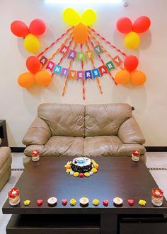 a living room filled with furniture and balloons hanging from the wall over a coffee table