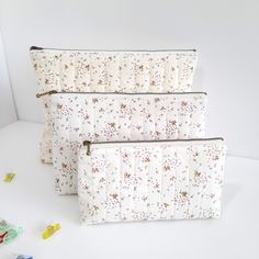 three zippered pouches sitting next to each other on top of a white table