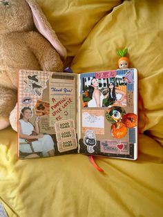 an open book sitting on top of a bed next to a stuffed animal