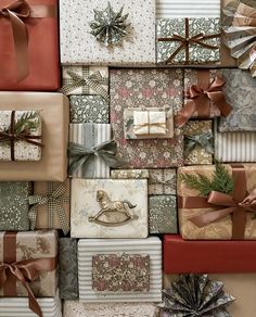 many wrapped presents are stacked on top of each other with ribbons and bows around them