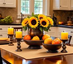 sunflowers and oranges sit in a bowl on a table with other plates