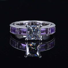 a princess cut diamond ring with purple and white stones on the band, set in 18k white gold