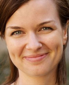 a close up of a woman smiling for the camera