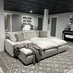 a living room with a large sectional couch and a rug on the floor in front of it