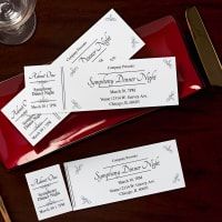 three place cards are sitting on a red plate next to silverware and wine glasses