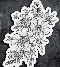 a sticker with flowers on it sitting on top of a black surface next to a wall