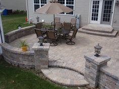 a patio with an umbrella and chairs around it