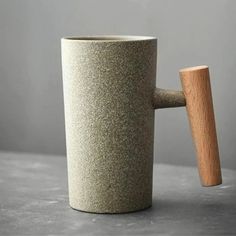 a coffee cup with a wooden handle on a table