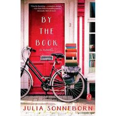 a bicycle parked in front of a red door with the words by the book written on it