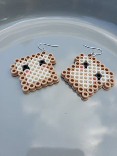 a pair of earrings made out of legos